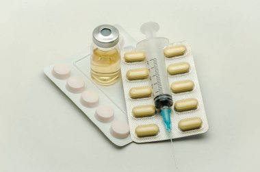 İlaçlar, vitaminler ve enjeksiyon için şırınga beyaz arka planda izole edilmiş ilaçlar