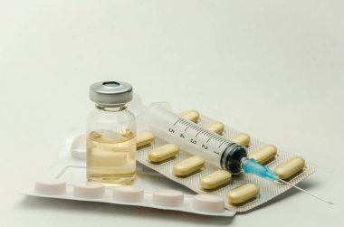 İlaçlar, vitaminler ve enjeksiyon için şırınga beyaz arka planda izole edilmiş ilaçlar