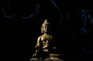 Siyah arka plan üzerine izole duman Buddha bronz