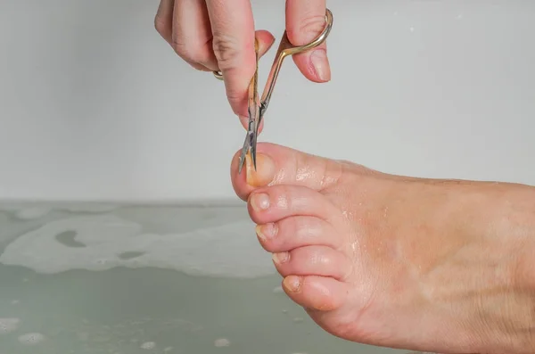 Uma Mulher Banho Tosquia Unhas Fazendo Uma Manicura Nas Pernas — Fotografia de Stock