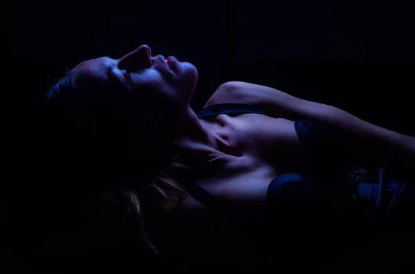 年轻性感的女孩在一个美丽的色情蕾丝内衣躺在一个黑色的背景孤立 — 图库照片