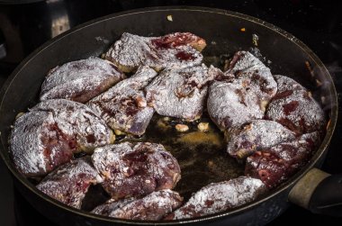 Aşçı bir indüksiyon Ocak tarihinde bir tavada kızarmış karaciğer hazırlar