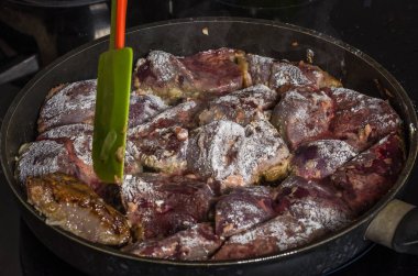 Aşçı bir indüksiyon Ocak tarihinde bir tavada kızarmış karaciğer hazırlar