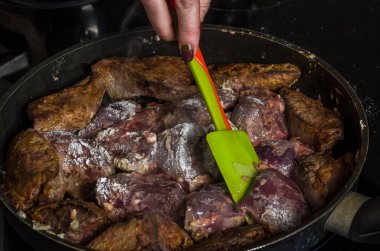 Aşçı bir indüksiyon Ocak tarihinde bir tavada kızarmış karaciğer hazırlar