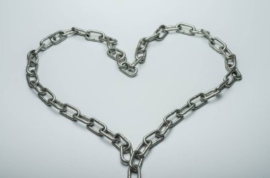 Beyaz zemin üzerinde bir zincir metal kalp
