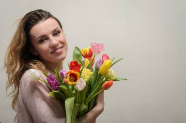 Bir buket çiçek - çok renkli Lale ile genç çekici kız
