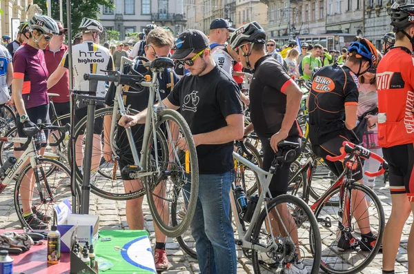 Lviv, Ukrayna - 2018 olabilir: Bisikletçi bisiklet delinmiş bir tekerlek pompa tarafından onarır