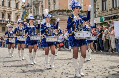 Lviv, Ukrayna - Mayıs 2018: Sevimli genç kız mavi karnaval kostümleri ve tüylü şehir merkezinde içinde geçit töreni sırasında şapka davul ile