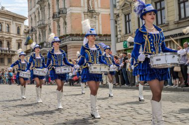 Lviv, Ukrayna - Mayıs 2018: Sevimli genç kız mavi karnaval kostümleri ve tüylü şehir merkezinde içinde geçit töreni sırasında şapka davul ile