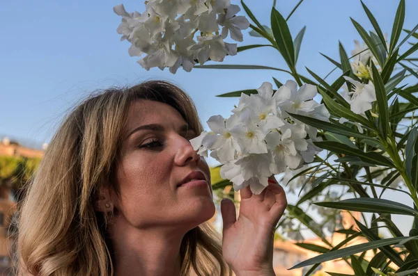 Menina Encantadora Jovem Cheira Flores Brancas Arbusto — Fotografia de Stock