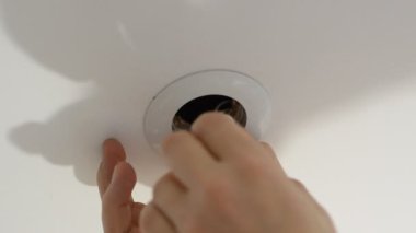 Elektrik işçisi tavandaki LED lambasını değiştirdi.