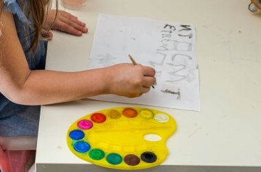 Küçük kız suluboya resimler çiziyor