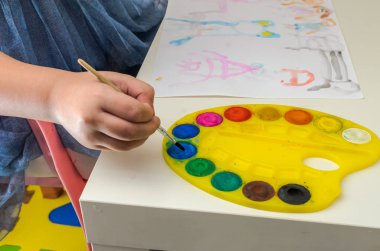 Küçük kız suluboya resimler çiziyor