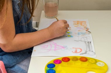 Küçük kız suluboya resimler çiziyor