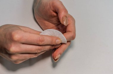 Kadın eski tırnak cilasını pamukla temizliyor, manikür yapıyor.