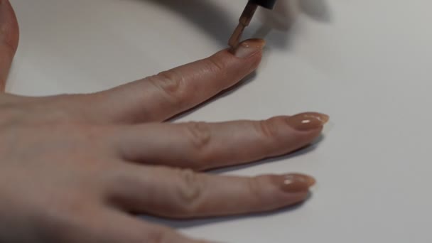 Kvinna Målar Naglar Med Beige Nagellack Medan Gör Manikyr — Stockvideo