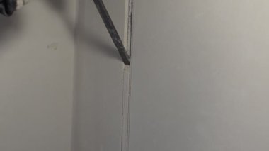 İşçi, bir delgi keskisiyle beton duvarı yıkıyor.