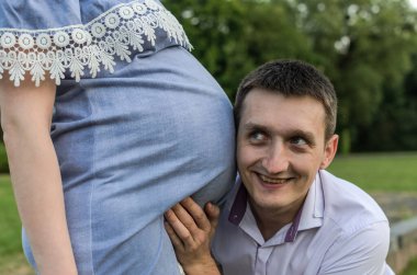 Genç müstakbel babası, hamile karısının karnının sesini dinliyor.