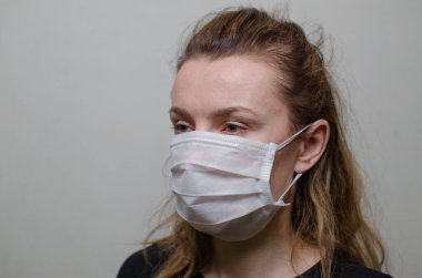 Genç kadın tıbbi bir maske takıyor.