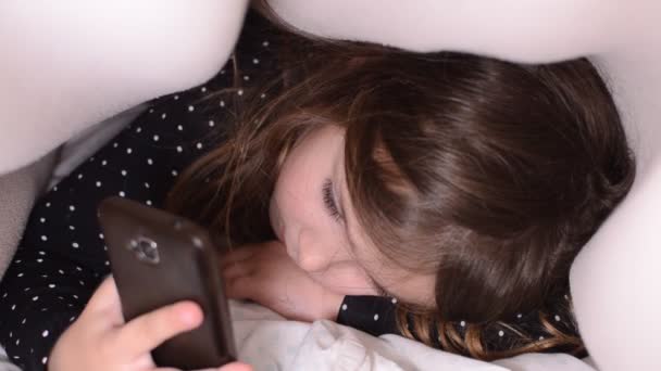 Menina Encantadora Criança Brincando Com Telefone Celular Sob Capas Cama — Vídeo de Stock