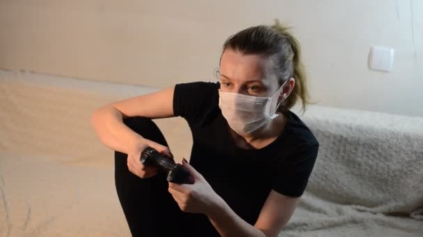 Een Jong Meisje Met Een Medisch Masker Speelt Een Computerconsole — Stockvideo