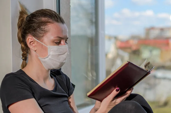 Young Girl Medical Mask Sits Windowsill Window Reads Book — Stock Photo, Image