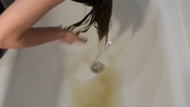 一位年轻女子染完头发后在浴室里洗了染发剂 — 图库视频影像