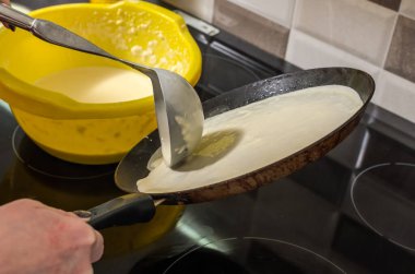 Pişirme fırınının üstünde tavada kızarmış krep.