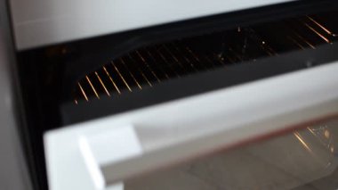 Aşçı çiğ, başsız uskumruyu limon ve mayonezle birlikte elektrikli fırına koyar.