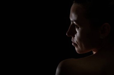 Karanlık bir arka planda izole edilmiş bir kızın silüeti.