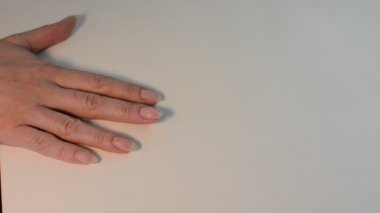 Kadın manikür yaparken ojeyle oje sürüyor.