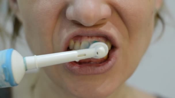 Женщина Чистит Зубы Электрической Зубной Щеткой — стоковое видео