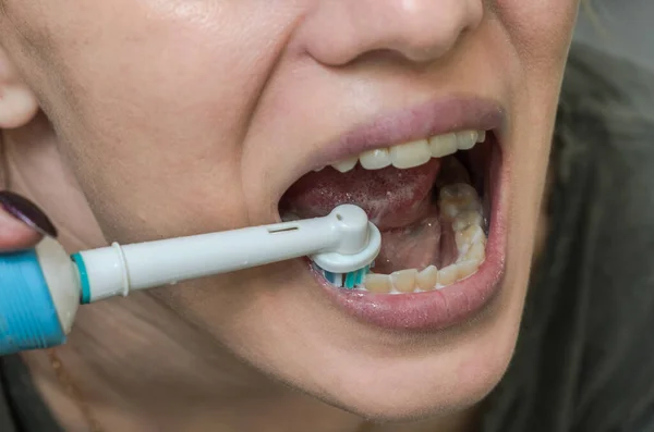 Kadın Dişlerini Elektrikli Diş Fırçasıyla Fırçalıyor — Stok fotoğraf