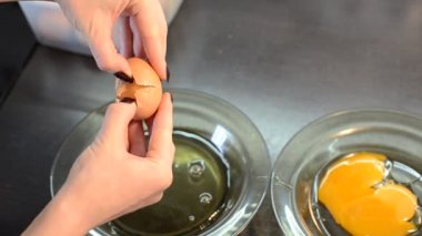 Kadın aşçı yumurta sarısını tabakta yumurta sarısından ayırır.