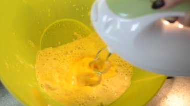 Tabaktaki elektrikli mikser hamuru kamçılıyor.