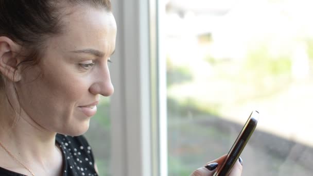 Young Woman Window Communicates Messenger Smartphone — Stock Video