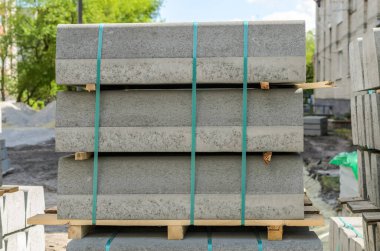 Ahşap paletler üzerindeki beton kaldırımlar sokak tamiri sırasında sokakta duruyor.