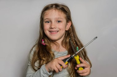 İki tornavidayla küçük sevimli bir kız.