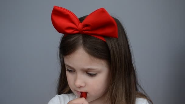 Маленькая Очаровательная Девочка Большим Бантом Голове Красит Губы Губной Помадой — стоковое видео