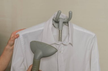 Buharlı ütüyle gömlek ütüleyen kadın