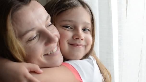 小さな女の子の子供 娘の抱擁とキス母親窓の近く 幸せな家族 — ストック動画