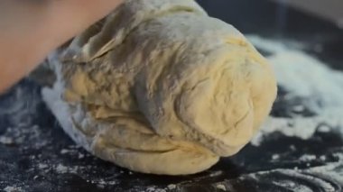 Aşçı ekmek yapmak için elleriyle hamur yoğurur.