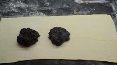 Aşçı ham hamura haşhaş hamuru yayar.