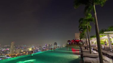 Singapur ünlü otel çatı katındaki yüzme havuzu panorama 4 k timelapse gece ışıklı