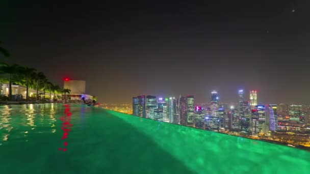 Night illuminated singapore famous hotel rooftop swimming pool downtown panorama 4k time lapse — Stock Footage Night illuminated singapore famous hotel rooftop swimming pool downtown panorama 4k time lapse Royalty Free Stock Video