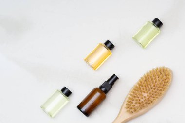Kozmetik küçük şişe kapları ve beyaz arka planda fırçalanmış vücut. Güzellik blogcusu, salon terapisi, markalaşma modeli, minimalizm konsepti. Düz yatıyordu