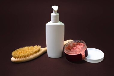 Kahverengi arka planda vücut fırçası, fırça ve vücut losyonu. Sessizlikler ön planda. Evde kişisel bakım. Refah kavramı.