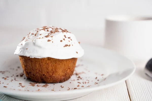 Muffin mit weißer Sahne und Schokoladenstreusel auf weißem Hintergrund. — Stockfoto