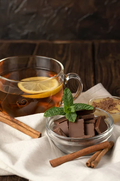 Uma xícara de chá preto perfumado com limão e chocolate com leite com hortelã e mel . — Fotografia de Stock