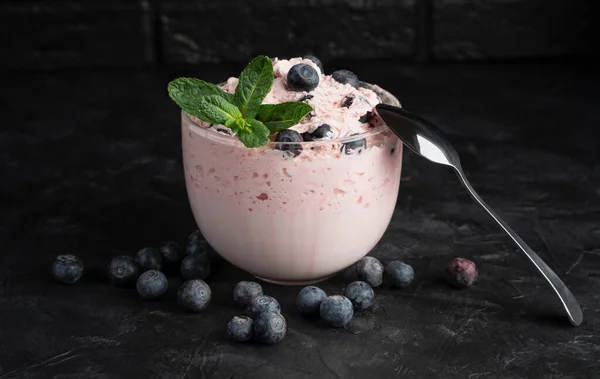 Cottage cheese dessert with cream and berries on a black background. — Stock Photo, Image